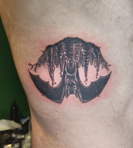 Tattoo einer hängender Fledermaus auf den Rippen