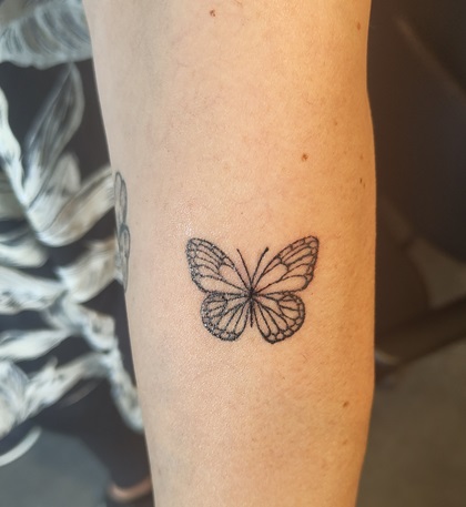 Tattoo eines Schmetterlings auf dem Unterarm