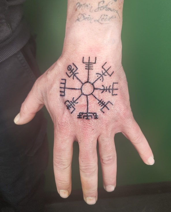 Tattoo eines Wegweiser im Vikinger-Stil auf dem Handrücken